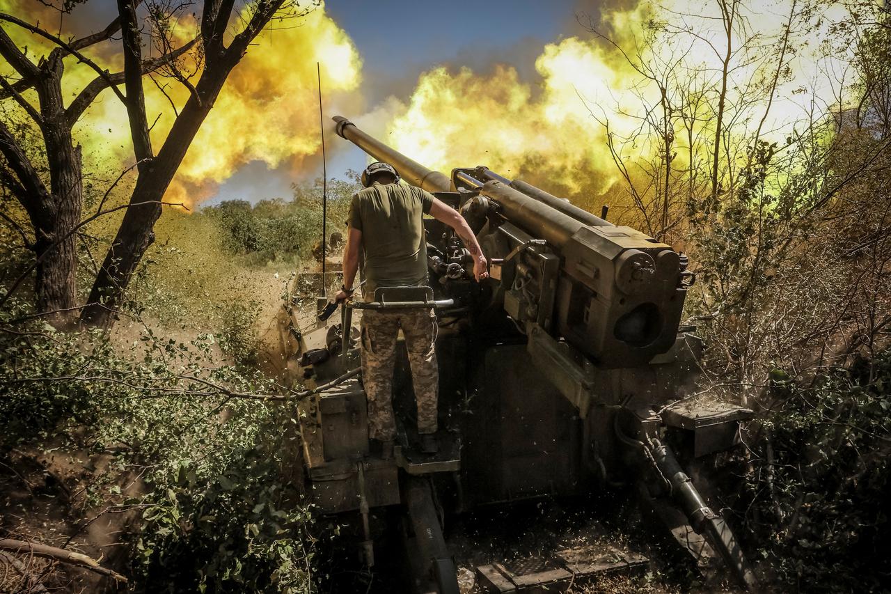 Ukrainian servicemen fire a self-propelled howitzer towards Russian troops at a frontline near the town of Chasiv Yar