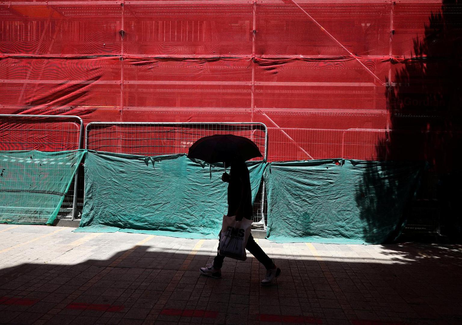 A man shelters from the sun with an umbrella during a heatwave in Nicosia, Cyprus July 15, 2023. REUTERS/Yiannis Kourtoglou      TPX IMAGES OF THE DAY Photo: Yiannis Kourtoglou/REUTERS