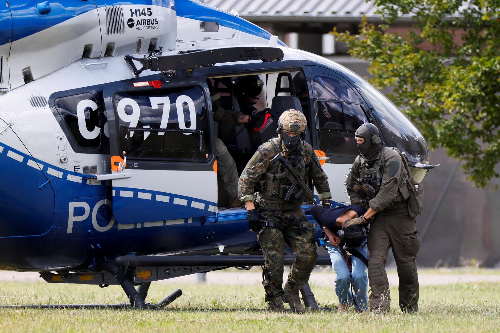 A 26-year-old Syrian man, who is the suspect in custody for a stabbing rampage in the western German city of Solingen in which several individuals were killed, is escorted by police on his way to the Federal Public Prosecutor in Karlsruhe, Germany, August 25, 2024. REUTERS/Heiko Becker Photo: Heiko Becker/REUTERS