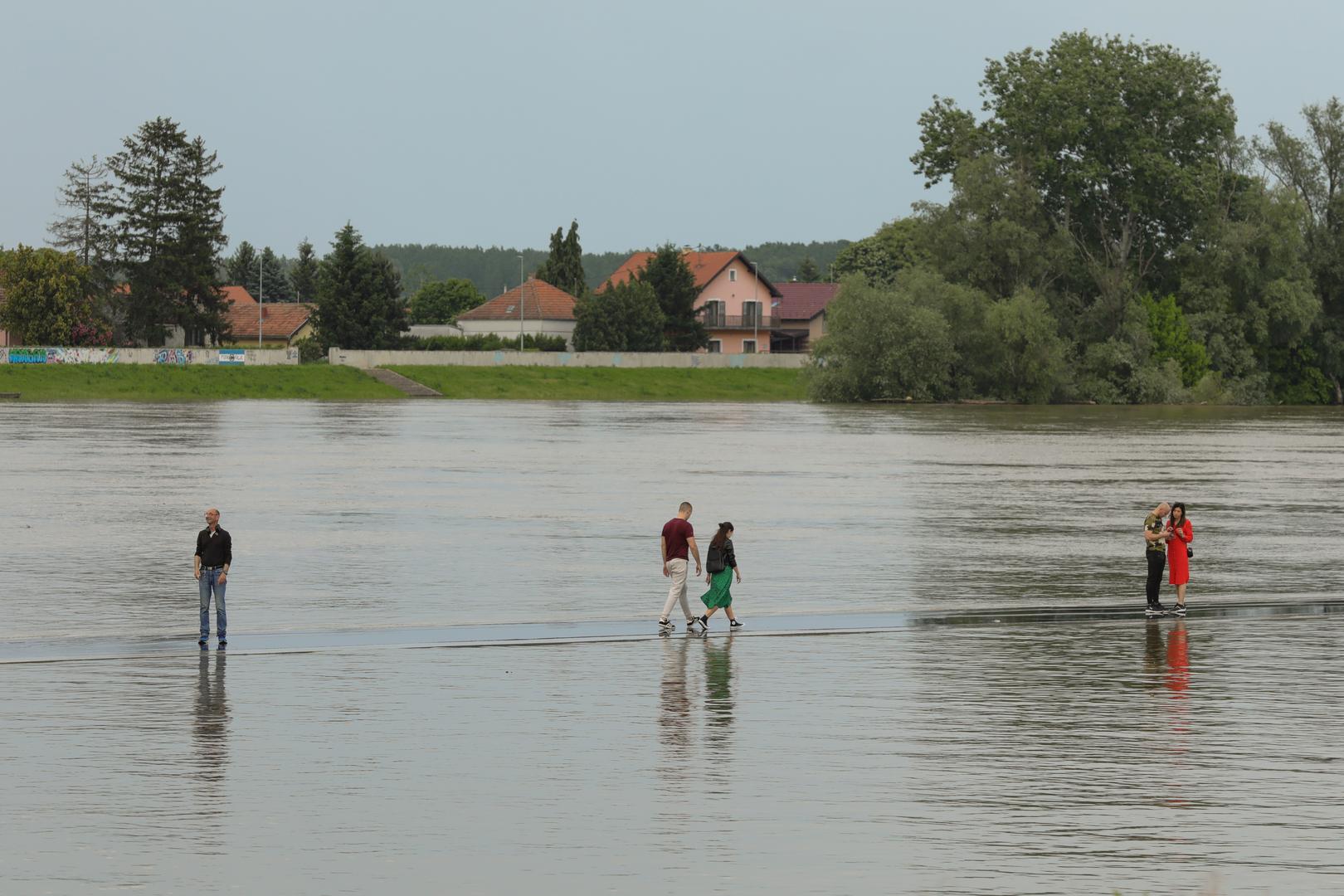 22.05.2023., Osijek - Vodostaj rijeke Drave raste iz sata u sat i dosegao je +356 centimetara. Prilaz novog luckog terminala preplavila je voda sto je Osjecanima bila prilika prosetati ''po vodi'' i napraviti zanimljive fotografije. Photo: Dubravka Petric/PIXSELL