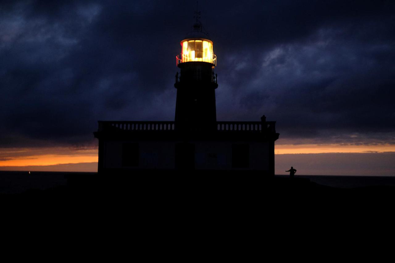 A pilgrim stands near the Corrubedo lighthouse, as he continues his pilgrimage on the Way of St. James (Camino De Santiago) near Ribeira