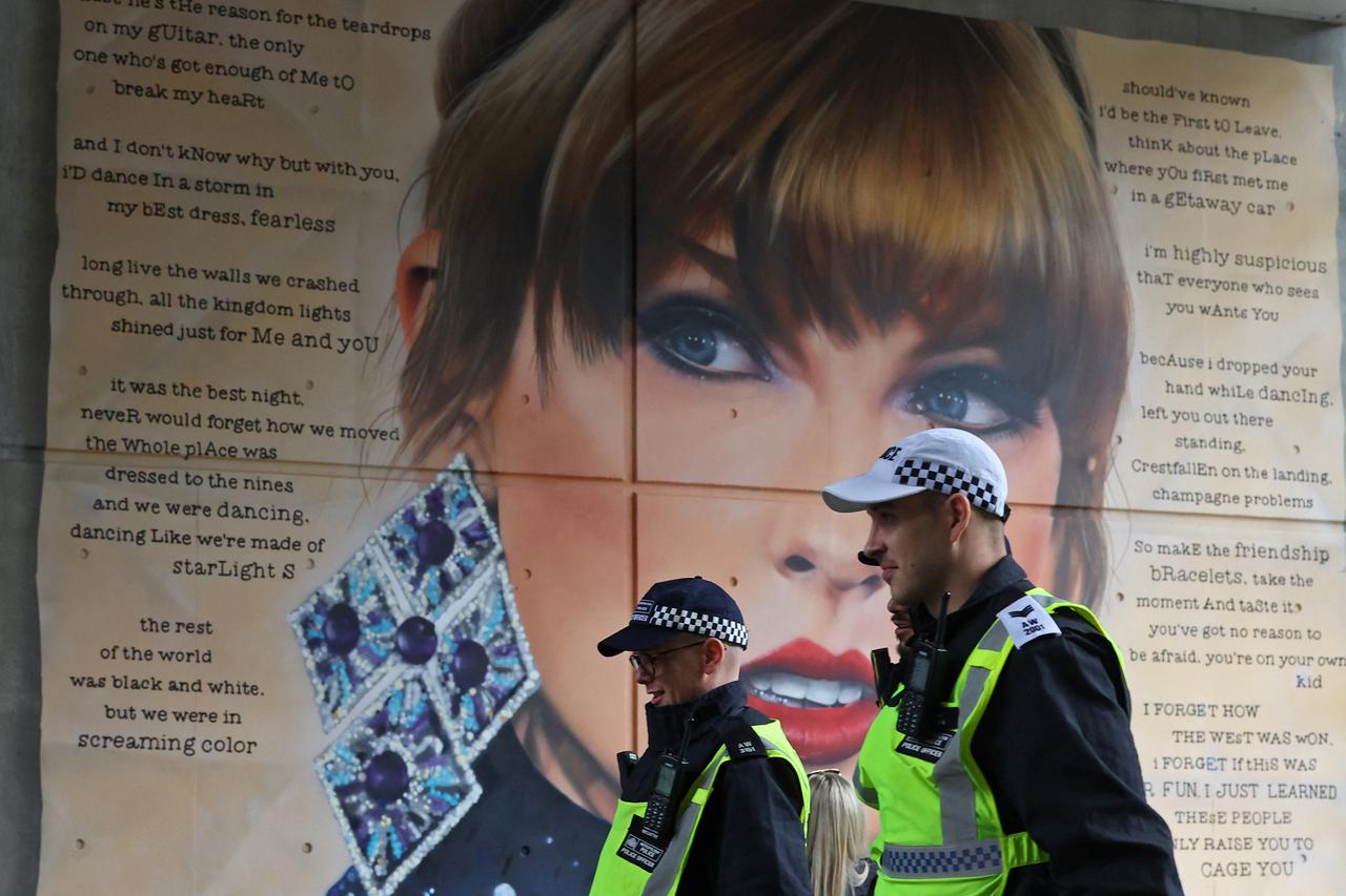 Police officers walk past a mural of Taylor Swift whilst on duty for Community Shield football match, at Wembley Stadium in London