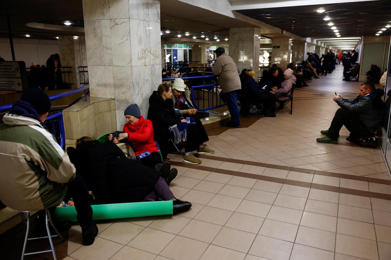 People take shelter inside a metro station during a Russian military attack, in Kyiv