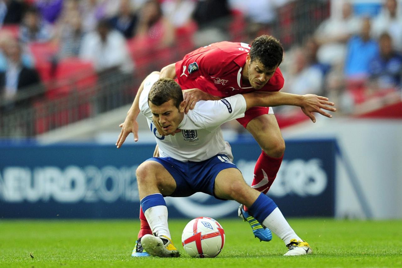 'England\'s midfielder Jack Wilshere (L) vies with Switzerland\'s midfielder Tranquillo Barnetta (R) during their UEFA Euro 2012 qualifying football match England vs Switzerland at Wembley football St