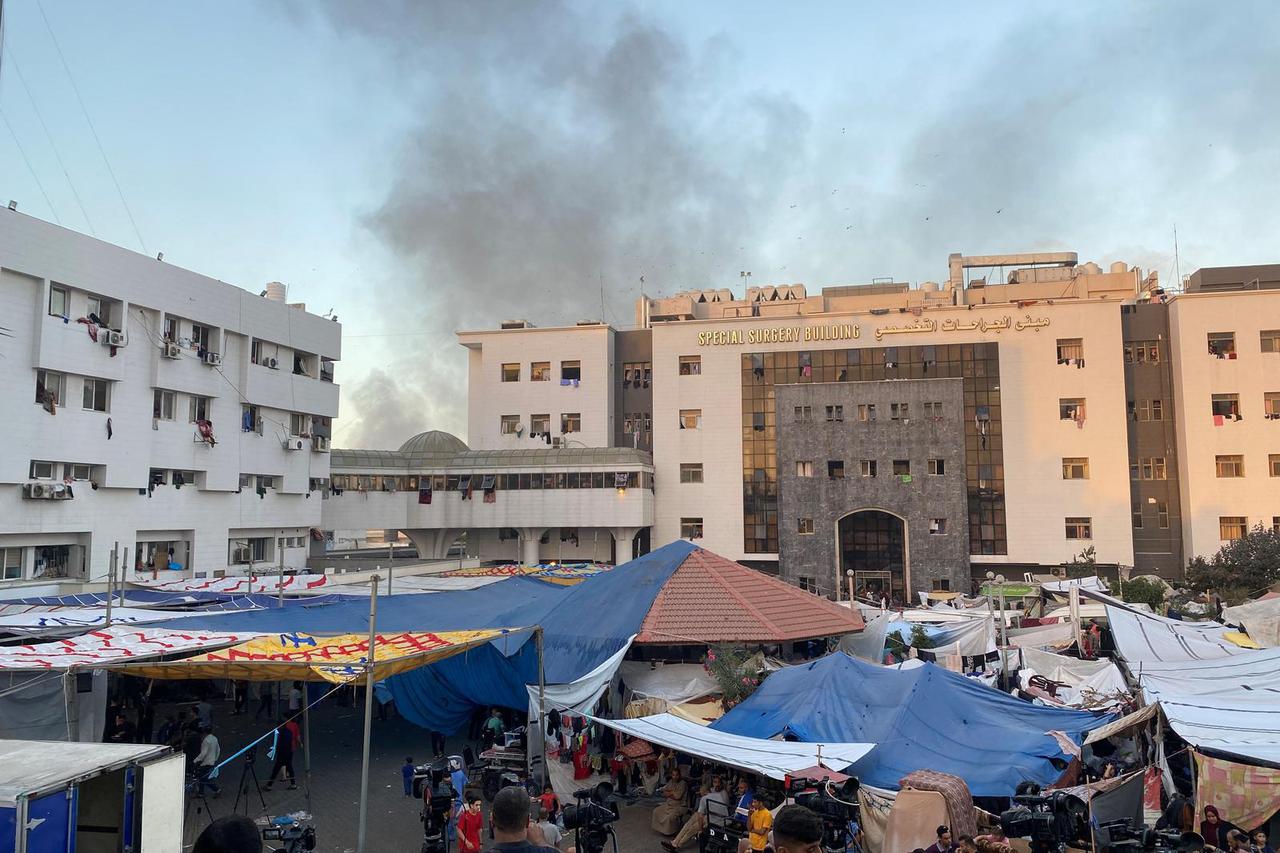 Smoke rises as displaced Palestinians take shelter at Al Shifa hospital, amid the ongoing conflict between Hamas and Israel, in Gaza City