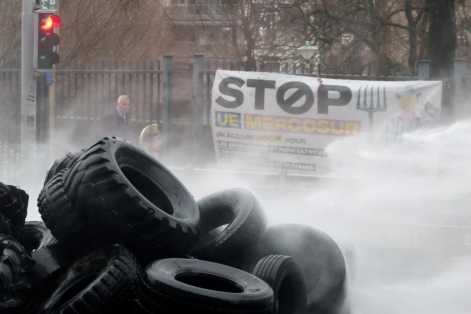 Tires are sprayed by a water cannon during a protest of European farmers over price pressures, taxes and green regulation, on the day of an EU Agriculture Ministers meeting in Brussels, Belgium February 26, 2024. REUTERS/Yves Herman Photo: YVES HERMAN/REUTERS