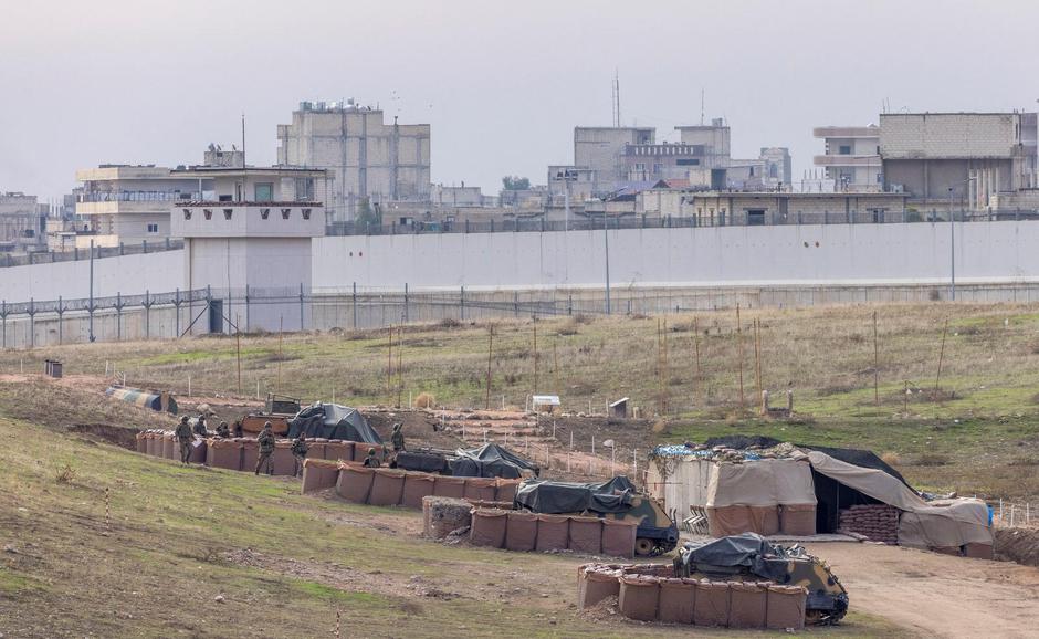 Turkish army vehicles are positioned at a military post as Syrian border town of Jarablus is seen behind  the Turkish-Syrian border line in Karkamis