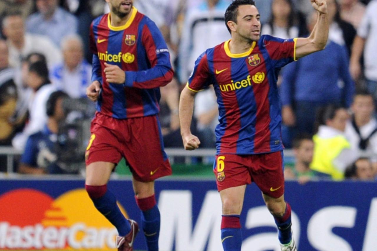 'Barcelona\'s defender Gerard Pique (L) and Barcelona\'s midfielder Xavi Hernandez (R) celebrates after teammate Barcelona\'s Argentinian forward Lionel Messi scored their first goal during the Champi