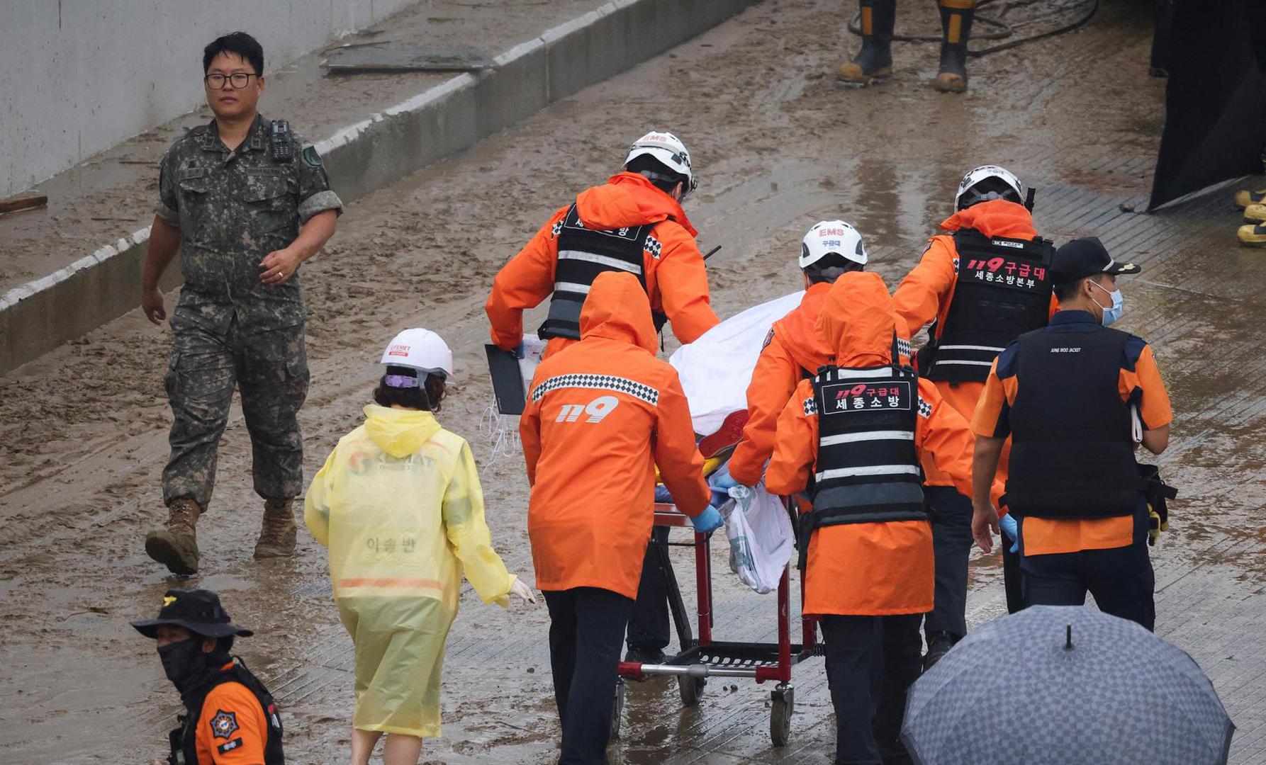 Rescue workers carry the body of a victim recovered during a search and rescue operation near an underpass that has been submerged by a flooded river caused by torrential rain in Cheongju, South Korea, July 16, 2023.   REUTERS/Kim Hong-ji Photo: KIM HONG-JI/REUTERS