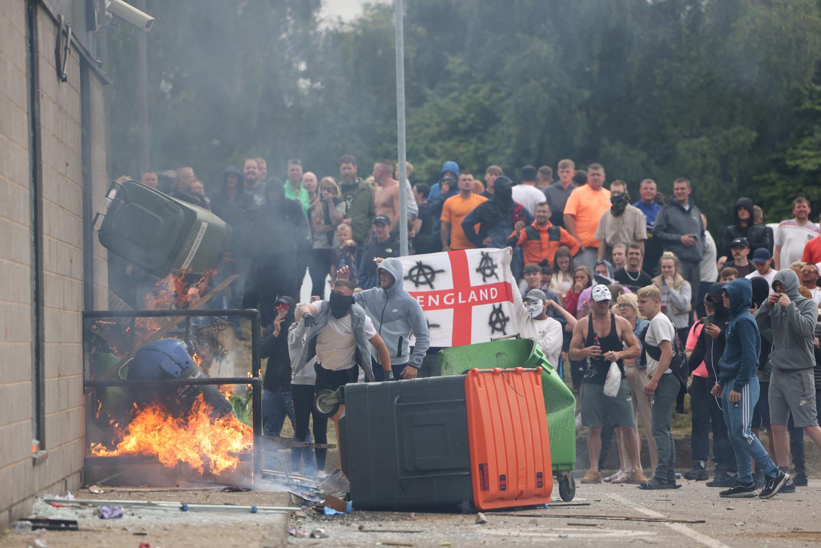 Protestors throw a garbage bin on fire towards a hotel in Rotherham, Britain, August 4, 2024. REUTERS/Stringer Photo: Stringer/REUTERS