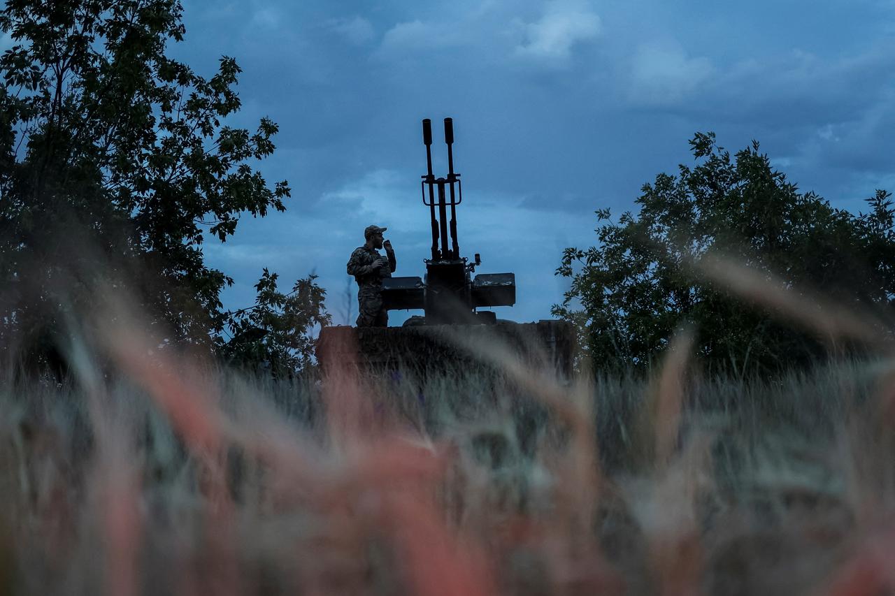 FILE PHOTO: A Ukrainian serviceman from an anti-drone mobile air defence unit smokes near an anti aircraft cannon as he waits for Russian kamikaze drones in Kherson region