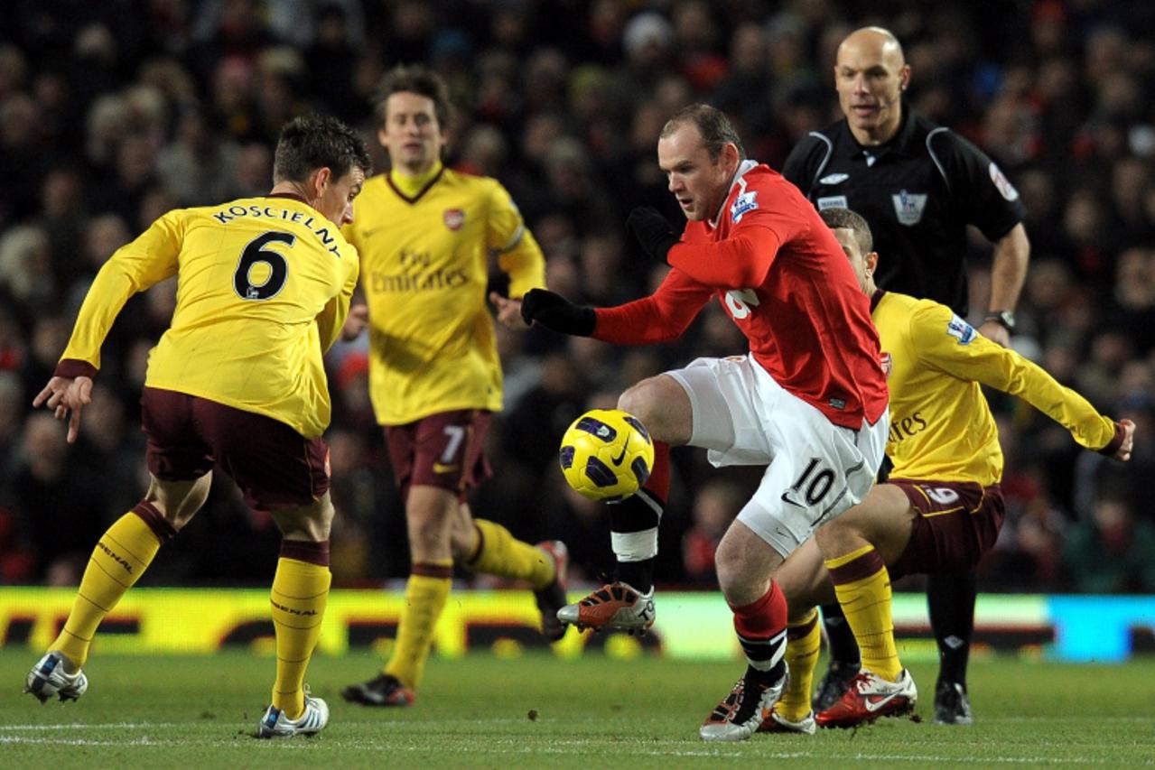 \'Manchester United\'s English forward Wayne Rooney (R) takes the ball past Arsenal\'s French defender Laurent Koscielny during the English Premier League football match at Old Trafford in Manchester,