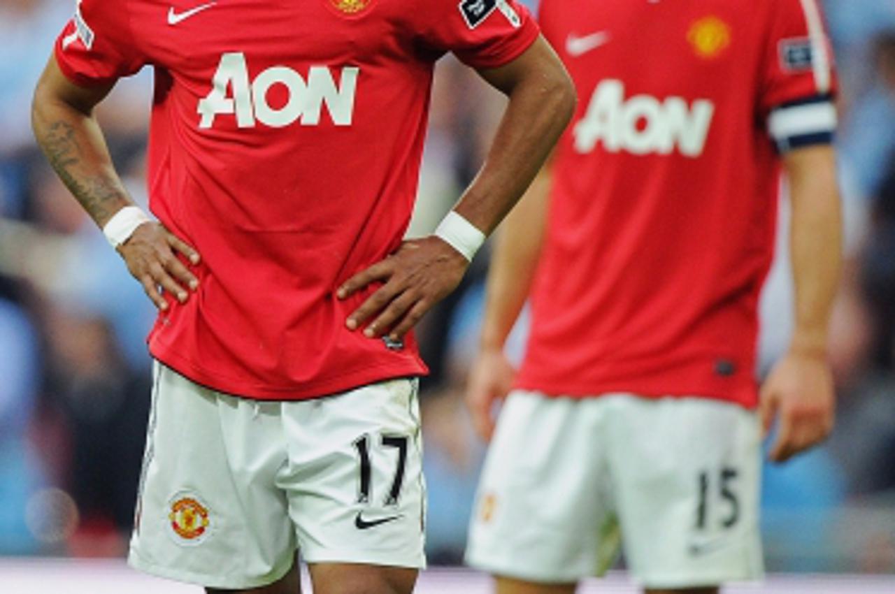 'Manchester United\'s Portuguese midfielder Nani (L) and Serbian defender Nemanja Vidic (R) react to their 1-0 defeat in the FA Cup semi-final football match between Manchester United and Manchester C