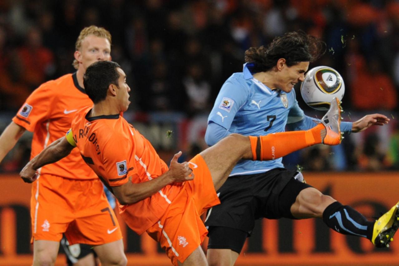 'Netherlands\' defender Giovanni van Bronckhorst (L) fights for the ball with Uruguay\'s striker Edinson Cavani during the 2010 World Cup semi-final match between Uruguay and Netherlands on July 6, 20