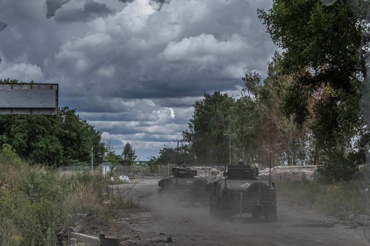 FILE PHOTO: Ukrainian soldiers ride military vehicles at a crossing point on the border with Russia in Sumy region