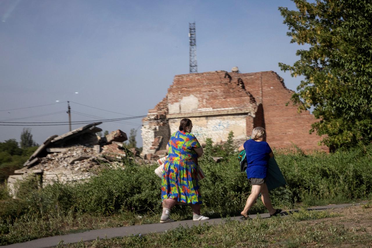 Women run for cover as rounds of shelling hit nearby in Selydove near Pokrovsk