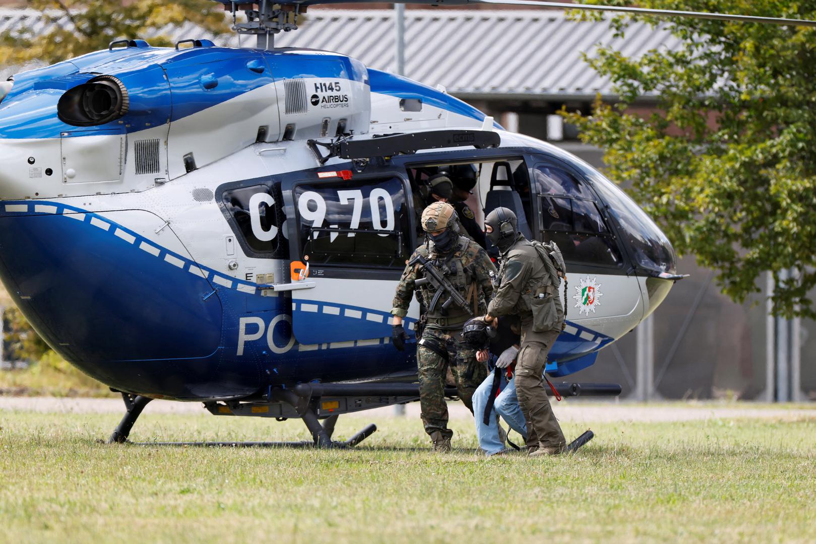 A 26-year-old Syrian man, who is the suspect in custody for a stabbing rampage in the western German city of Solingen in which several individuals were killed, is escorted by police on his way to the Federal Public Prosecutor in Karlsruhe, Germany, August 25, 2024. REUTERS/Heiko Becker Photo: Heiko Becker/REUTERS