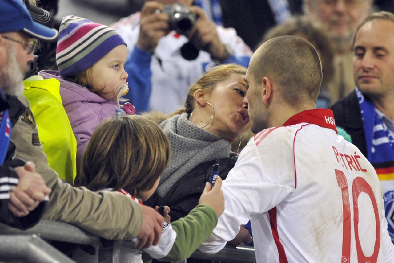 'Hamburg SV\'s Mladen Petric kisses his wife Despina as he hands over their daughter Melina Charlize after celebrating victory on the pitch after the German Bundesliga first division soccer match agai