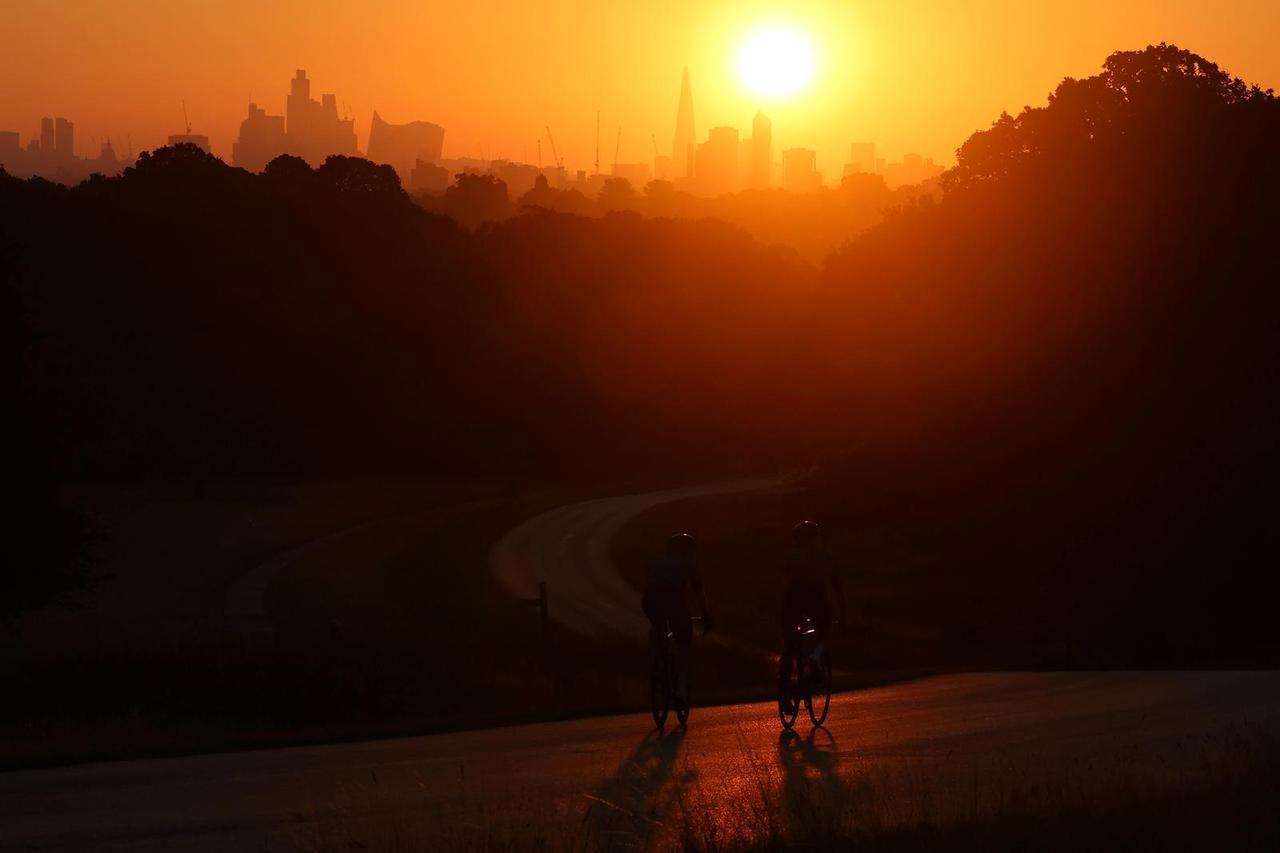 Sun rises above the city skyline during hot weather, in London