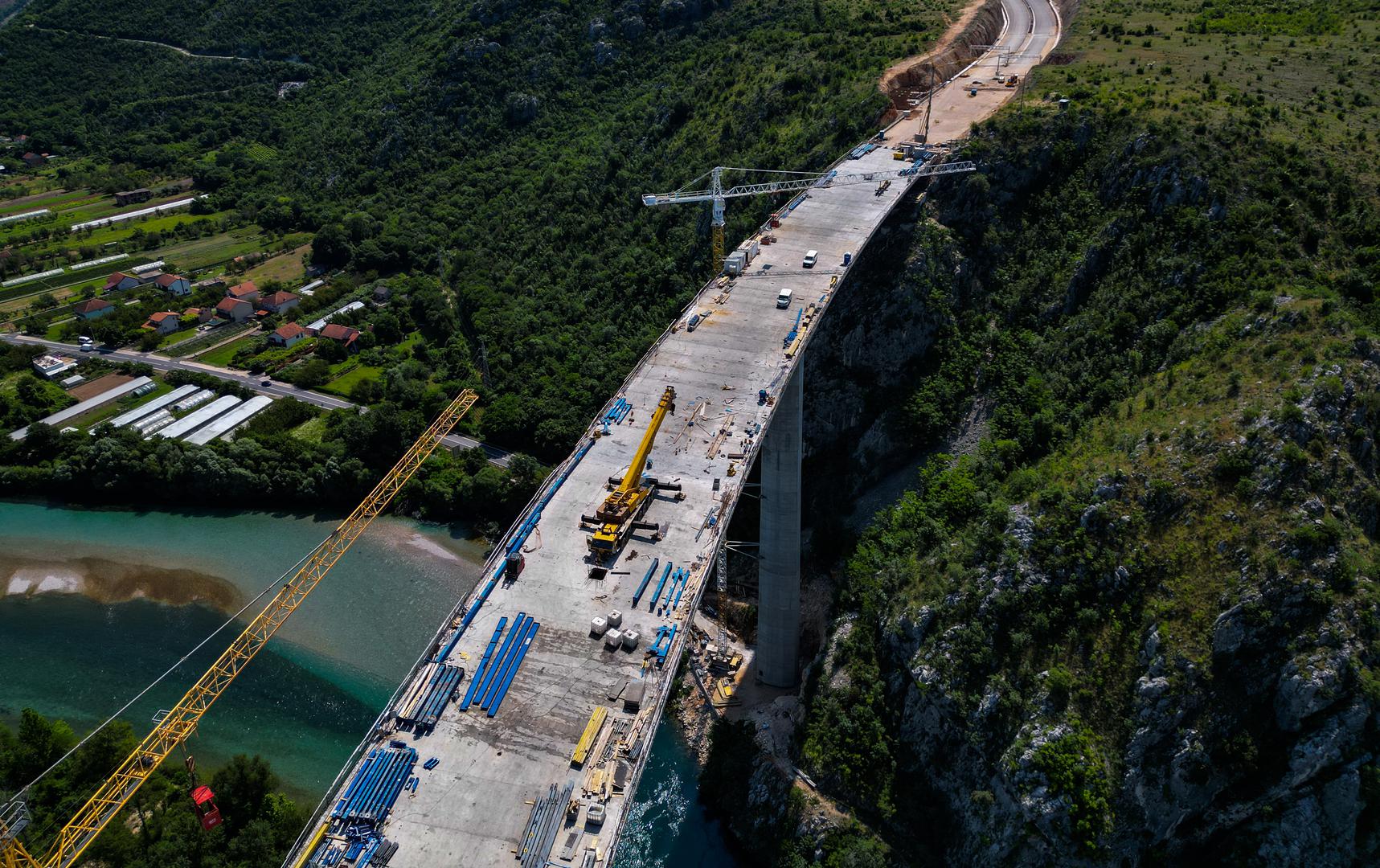 18.06.2023.,Capljina -  Jedan od najvisih mostova u regiji, most Pocitelj uskoro ce biti  spojen s lijevom obalom Neretve. Most Pocitelj visok je nesto vise od stotinu metara, dok njegova duzina iznosi 918 metara. Most ce imati dva vozna traka u svakom smjeru, te je projektiran za brzinu do 130 kilometara na sat. Specificnost ovog mosta je da se citava sirina raspona nalazi na jednostrukom nizu stupova, tj, kolnici nisu fizicki odvojeni. Most Pocitelj najveci je objekt na koridoru Vc. 


 Photo: Denis Kapetanovic/PIXSELL