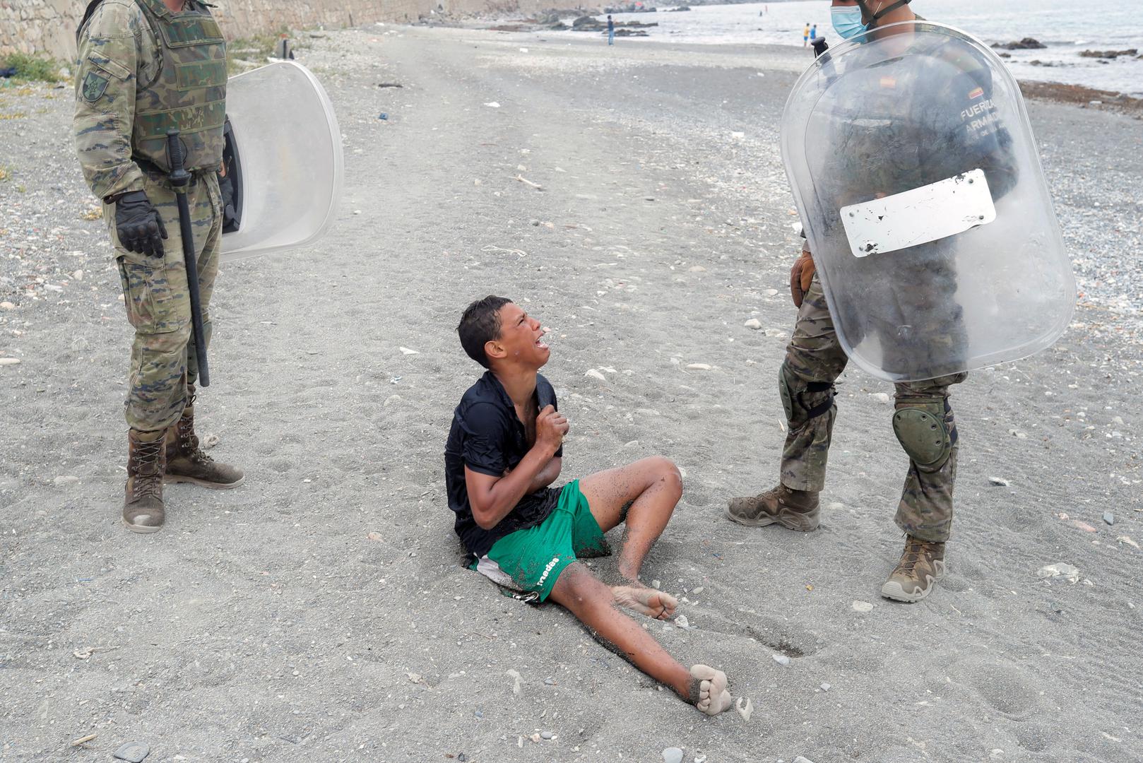 Thousands of migrants cross the Spanish-Moroccan border A Moroccan boy cries as he is helped by Spanish soldiers after he swam using bottles as a float, at El Tarajal beach, near the fence between the Spanish-Moroccan border, after thousands of migrants swam across the border, in Ceuta, Spain, May 19, 2021. REUTERS/Jon Nazca JON NAZCA