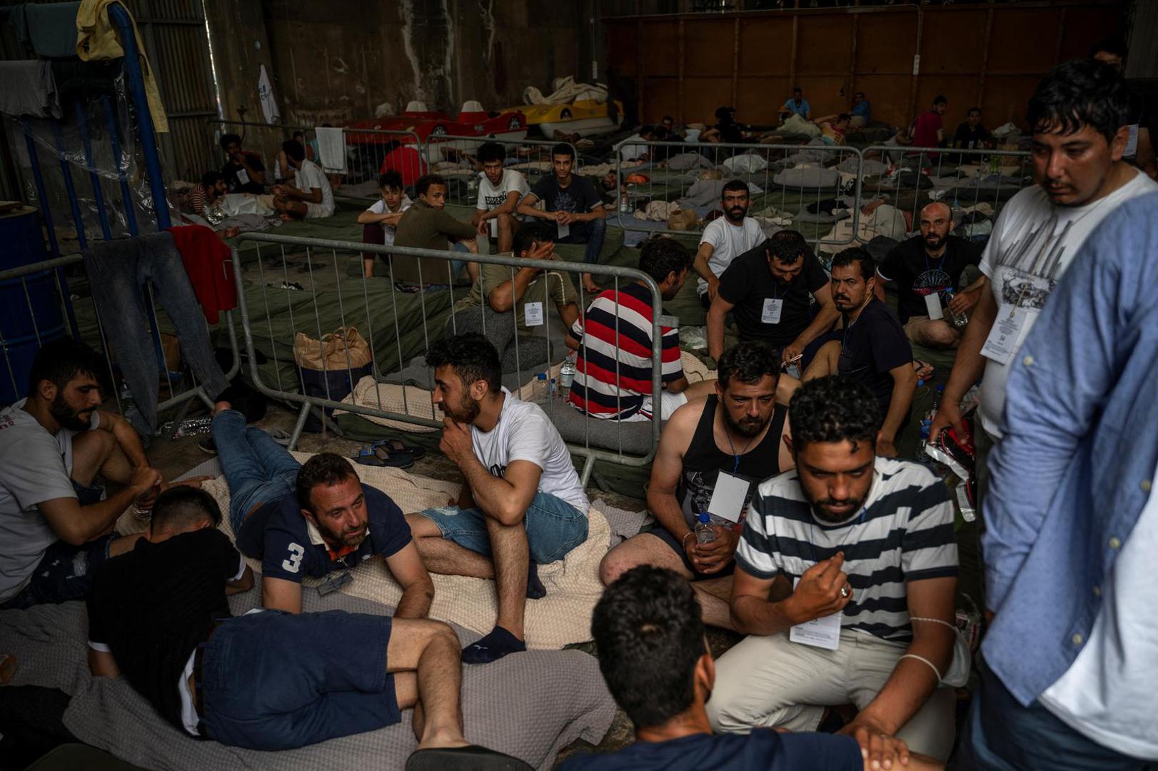 Migrants who were rescued at open sea off Greece along with other migrants, after their boat capsized, are seen inside a warehouse, used as shelter, at the port of Kalamata, Greece, June 15, 2023. Angelos Tzortzinis/Pool via REUTERS Photo: POOL/REUTERS