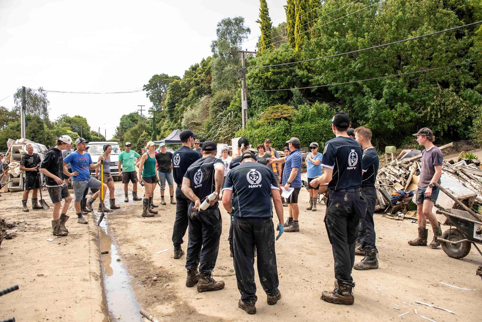 HMNZS Te Mana crew members help with a clean up after a small creek bursts its bank causing houses to flood in Havelock North, New Zealand, February 18, 2023.  New Zealand Defence Force/Handout via REUTERS    THIS IMAGE HAS BEEN SUPPLIED BY A THIRD PARTY NO RESALES. NO ARCHIVES MANDATORY CREDIT Photo: New Zealand Defence Force/REUTERS