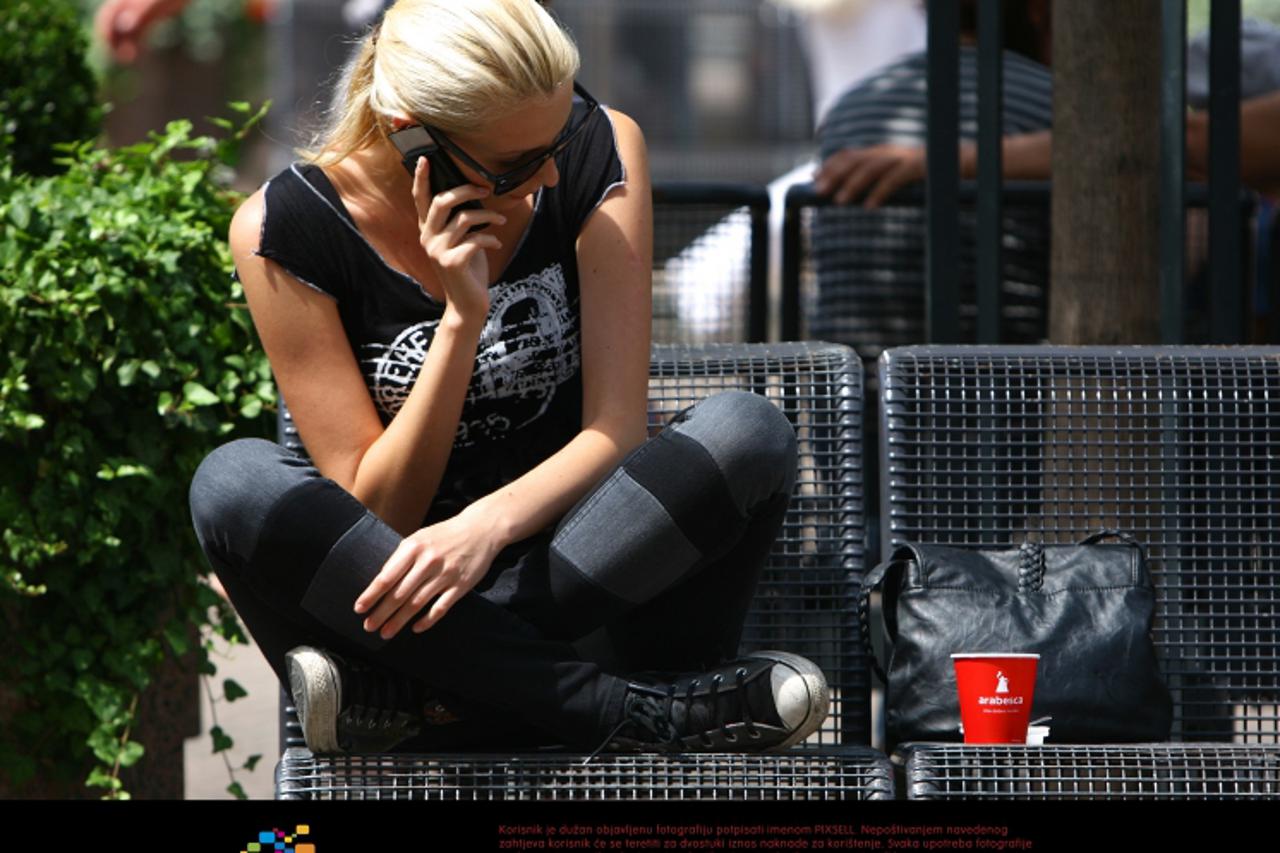 '01.08.2011., Zagreb - Mlada djevojka uziva uz kavu i telefon uz lijepo vrijeme koje se ponovno pojavilo nakon duzeg razdoblja niskih temperatura i kise.  Photo: Tomislav Miletic/PIXSELL'