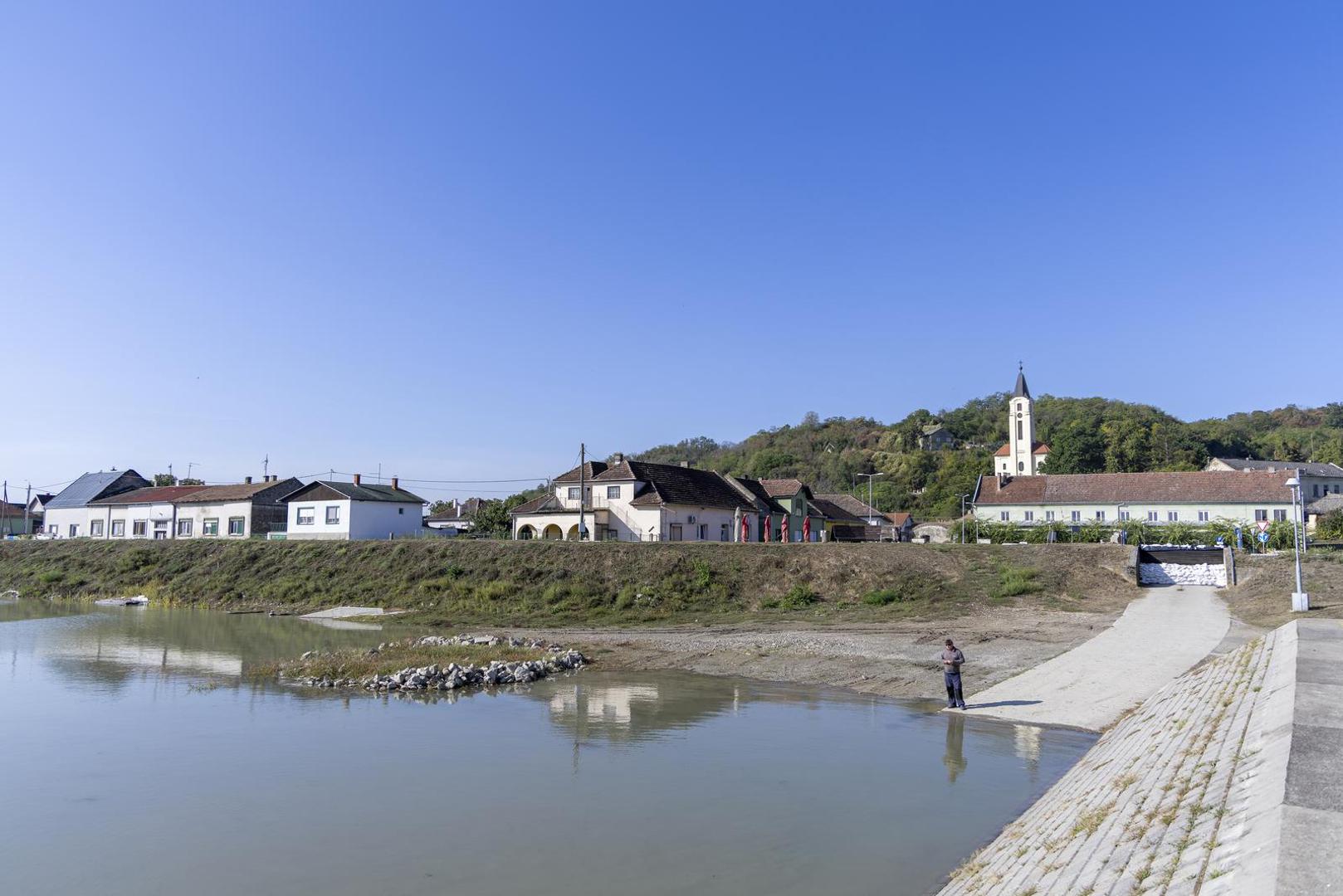 18.09.2024., Batina - Zeleni otok i Batina pripremaju se za dolazak vodenog vala na Dunavu koji stize krajem tjedna. Procjene su da bi vodostaj mogao dosegnuti do 750 centimetara. Mjestani pune vrece s pijeskom kako bi napravili zecje nasipe te postavljaju grede na prolazima za camce, a u naselju Zeleni otok namjestaj i ostalu vrijednu imovinu prebacuju na kat.  Photo: Borna Jaksic/PIXSELL