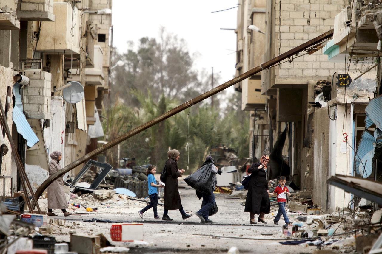 Residents carry belongings they collected from their damaged homes as they walk during a return visit to the city of Palmyra, Syria April 9, 2016. REUTERS/Omar Sanadiki      TPX IMAGES OF THE DAY