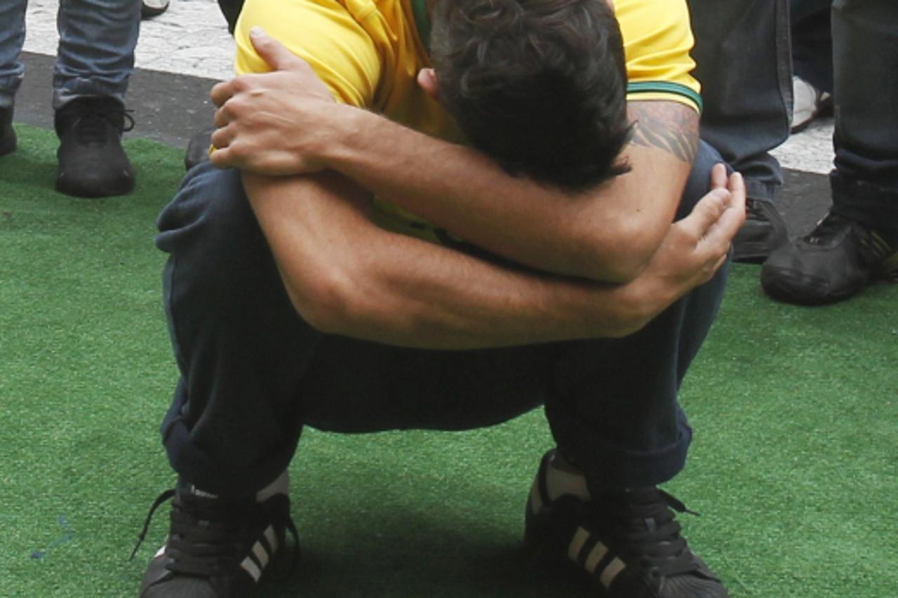 'A Brazilian soccer fan reacts as he watches a public screening of the FIFA World Cup soccer match between Brazil and the Netherlands, in front of Peru\'s government palace in Lima, July 2, 2010.  REU