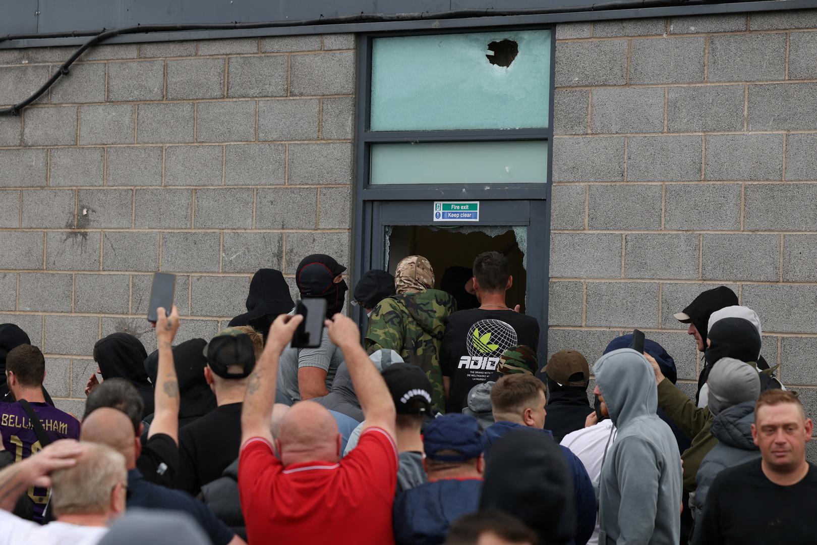 Protestors try to get inside a hotel through a damaged fire exit in Rotherham, Britain, August 4, 2024. REUTERS/Stringer Photo: Stringer/REUTERS