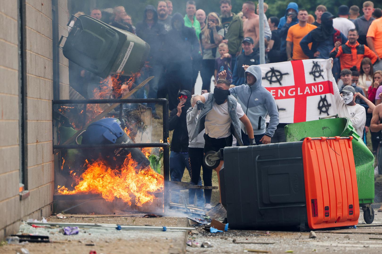 Protestors throw a garbage bin on fire outside a hotel in Rotherham, Britain, August 4, 2024. REUTERS/Stringer Photo: Stringer/REUTERS