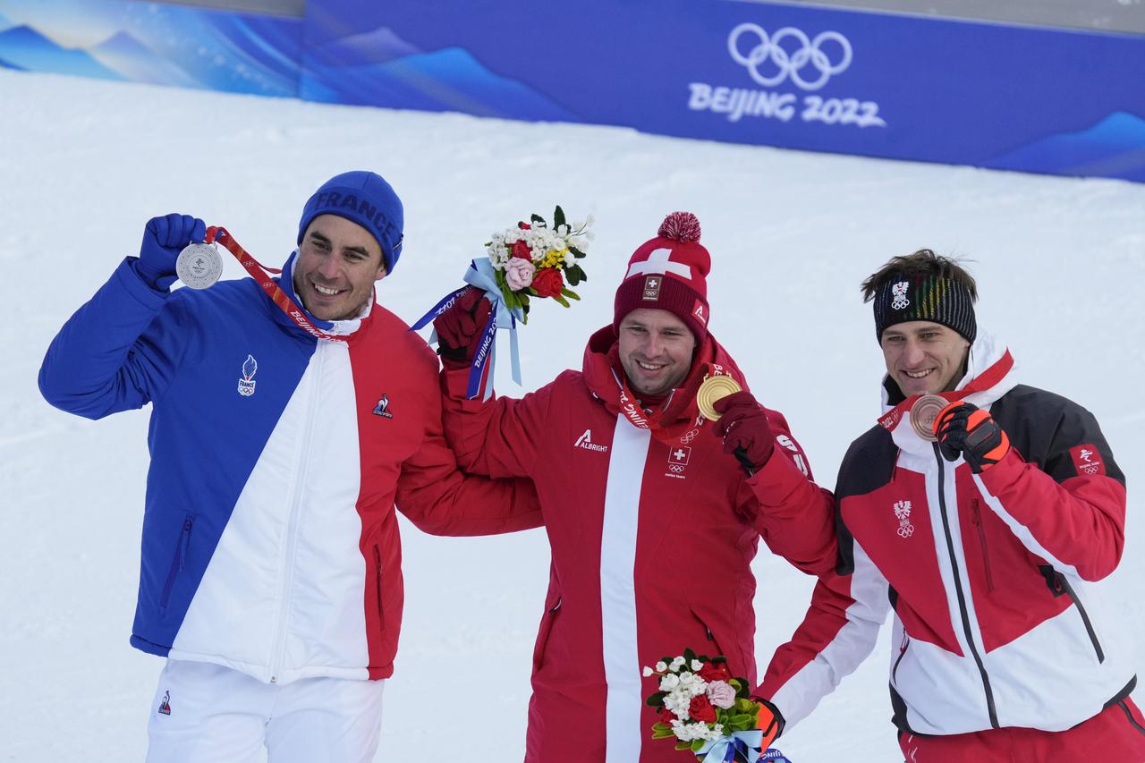 Winners hold up medals at the Men's Downhill race at the Beijing 2022 Winter Olympics