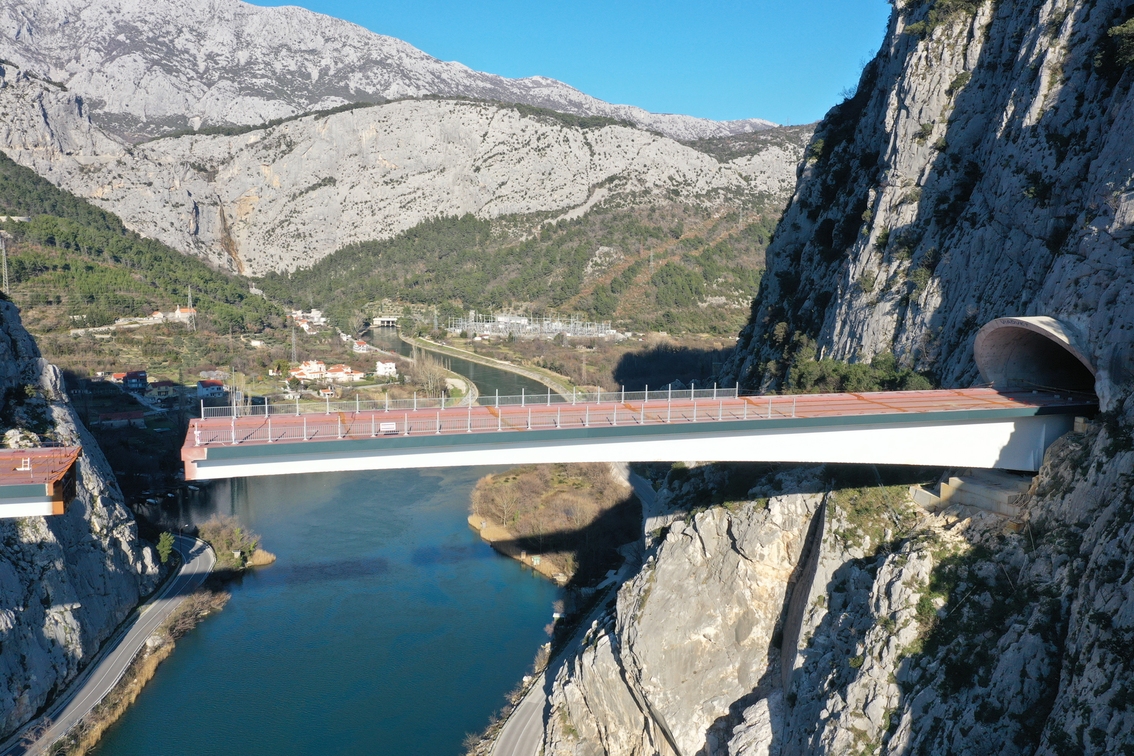 09.02.2023., Omis - Spajanje mosta iznad rijeke Cetine kod Omisa na 70 metara nadmorske visine koji je dio omiske zaobilaznice. Omiska obilaznica jedan od najvecih infrastrukturnih objekata u Splitsko-dalmatinskoj zupaniji, a zaobilaznicu ukljucuju dva tunela i most preko Cetine, tunel Komorjak dug vise od 600 metara, a Omis vise od 500 metara, dok ce most biti u duzini od 216 metara. Investitor je tvrtka Hrvatske ceste, koja je za prvu fazu brze ceste Split - Omis izdvojila 174,5 milijuna kuna, a s radovima se pocelo u rujnu 2019.  Photo: Matko Begovic/PIXSELL