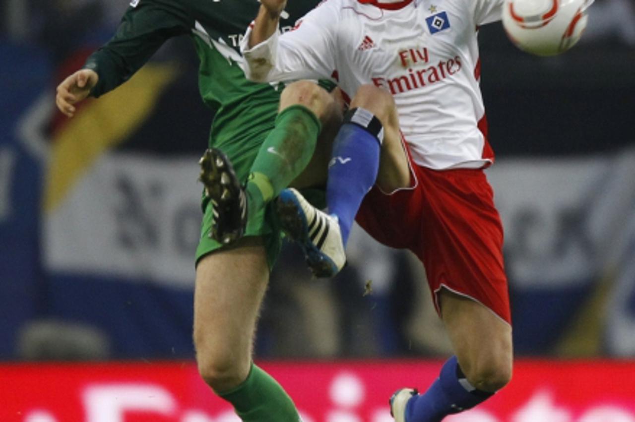 \'Werder Bremen\'s Per Mertesacker competes for the ball with Hamburg SV\'s Mladen Petric (R) during their German Bundesliga first division soccer match in Hamburg February 19, 2011. REUTERS/Christian