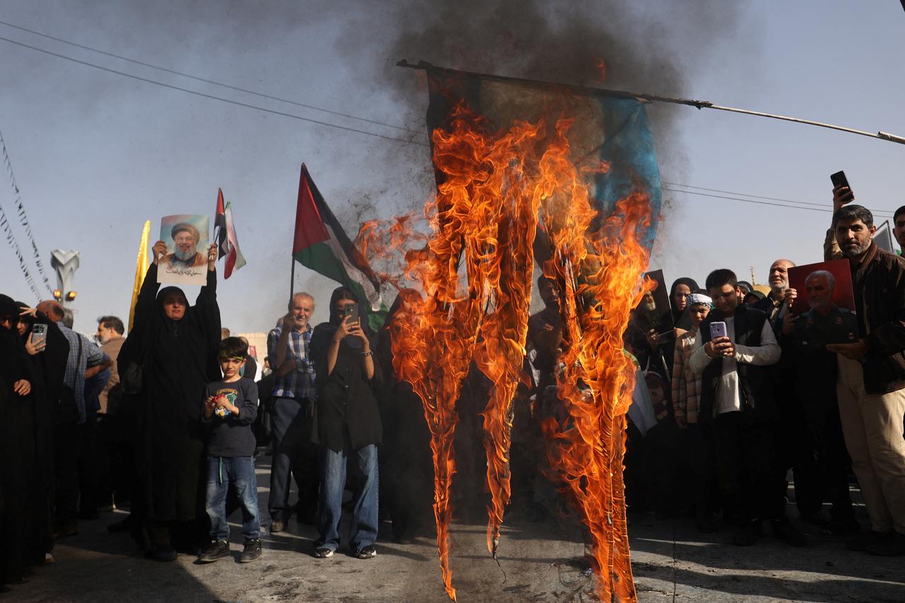 Iranians burn a painted Israeli flag during a gathering to support the IRGC attack on Israel, in Tehran