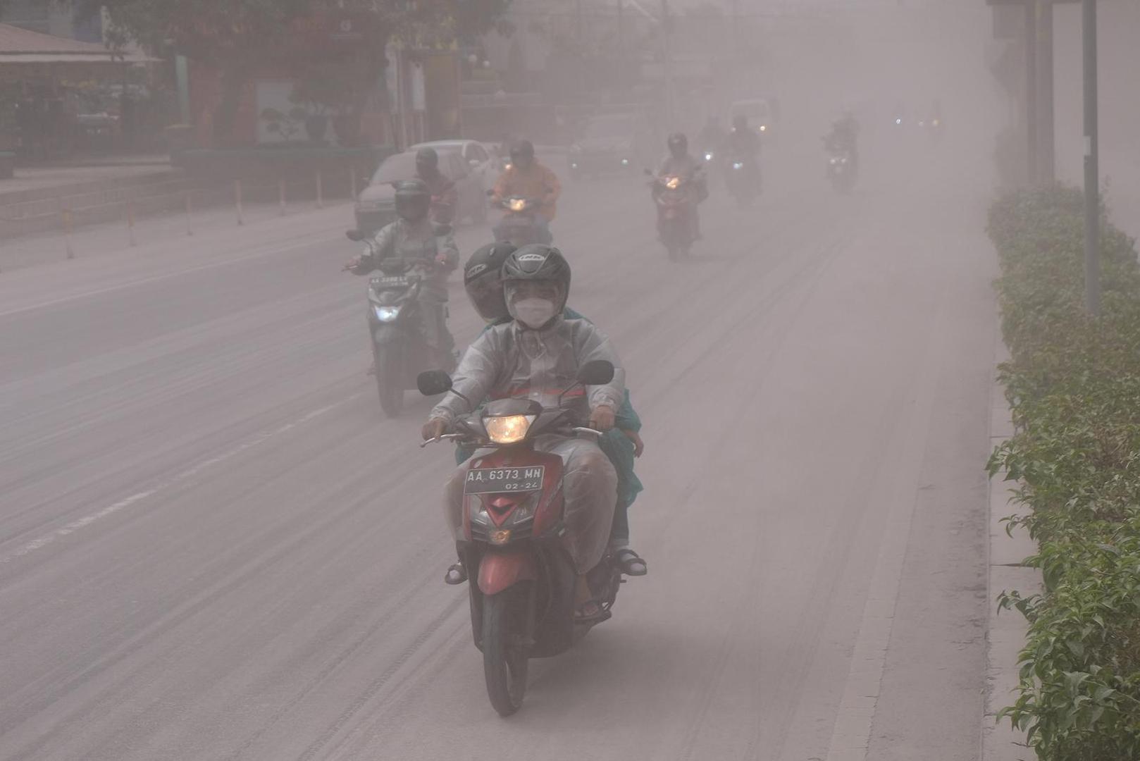 People ride on a road covered by ash from the eruption of Indonesia's Mount Merapi?volcano, in Magelang, Central Java province, Indonesia, March 11, 2023. Antara Foto/Anis Efizudin/via REUTERS ATTENTION EDITORS - THIS IMAGE HAS BEEN SUPPLIED BY A THIRD PARTY. MANDATORY CREDIT. INDONESIA OUT. NO COMMERCIAL OR EDITORIAL SALES IN INDONESIA. Photo: ANTARA FOTO/REUTERS