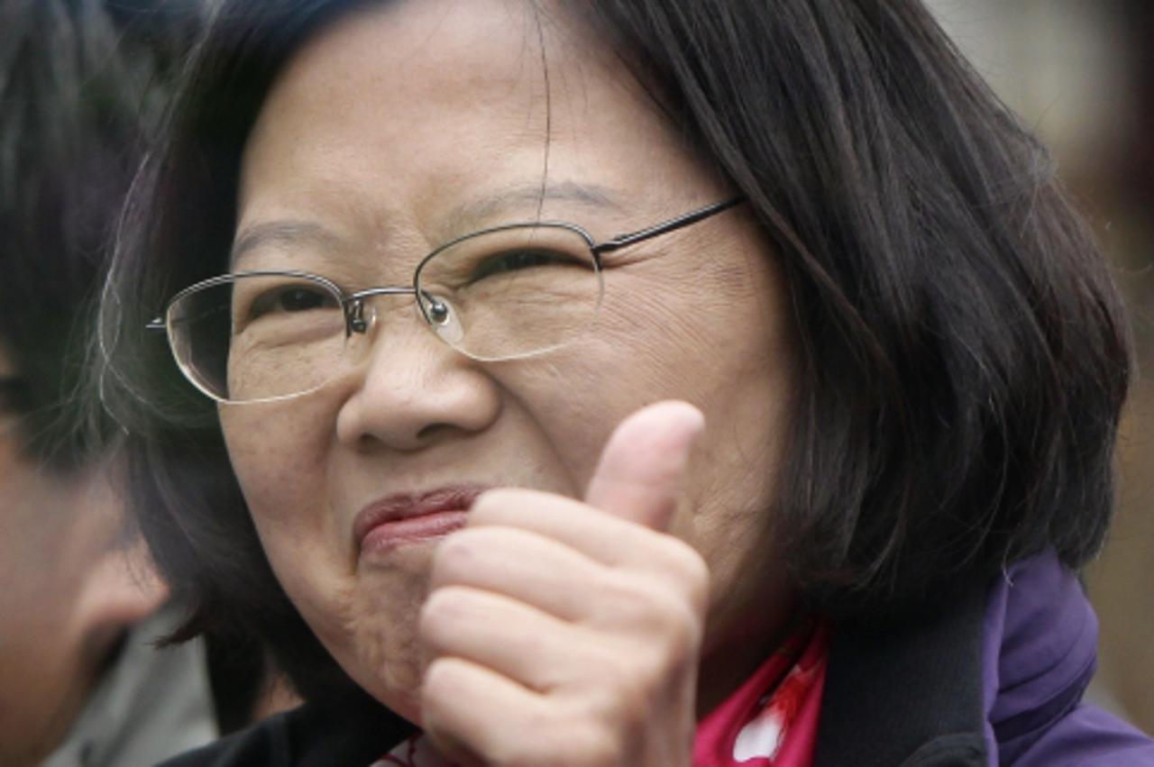 \'Taiwan\'s Democratic Progressive Party (DPP) Chairperson and presidential candidate Tsai Ing-wen (C) reacts as she gestures to supporters behind bullet-proof glass from her vehicle while campaigning