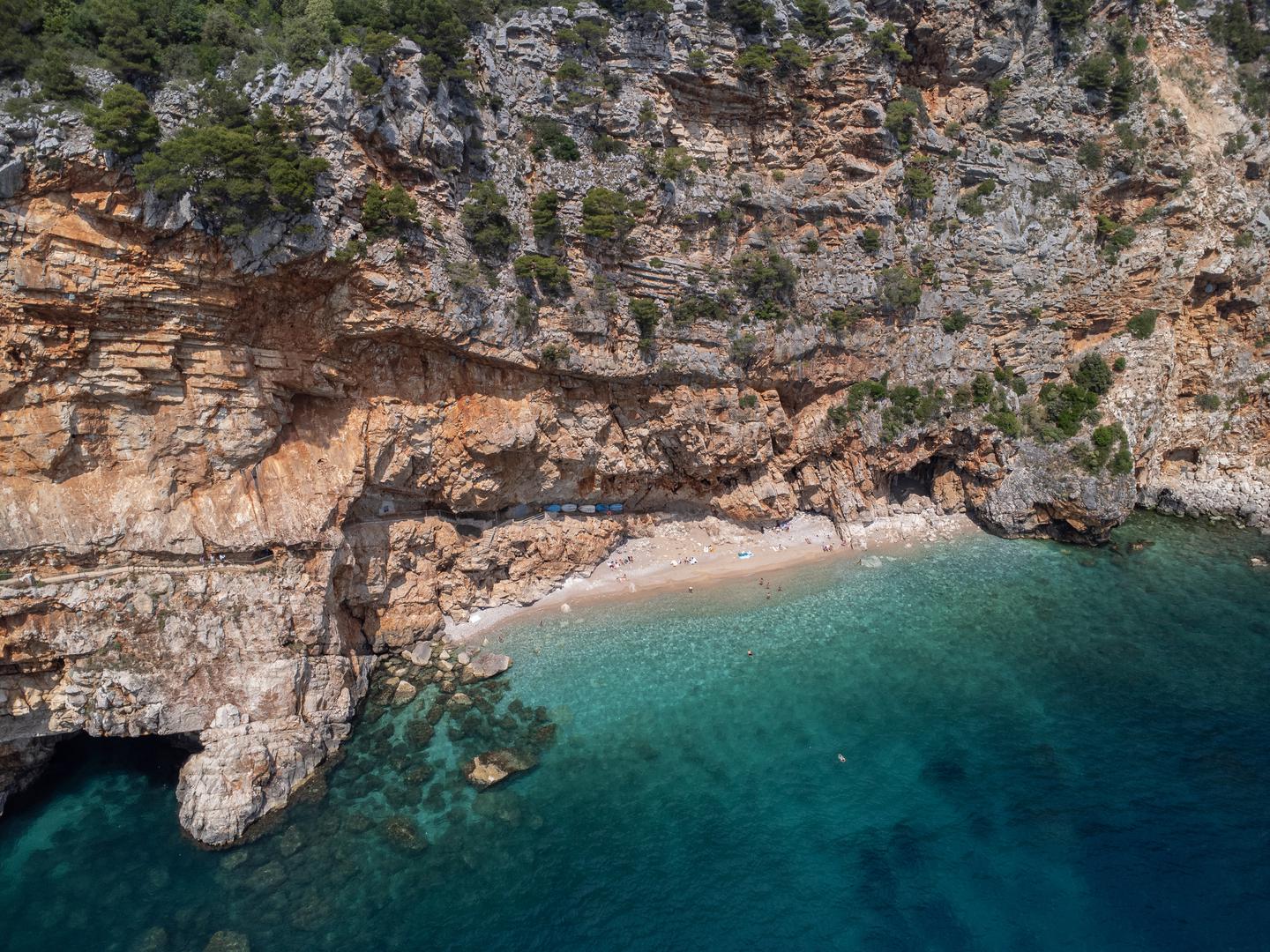 Pasjača, Konavle. Ova plaža nalazi se u južnoj Dalmaciji, a od Dubrovnika je udaljena 40 minuta. Da biste tamo stigli, prvo ćete stići u selo Popovići. Pasjača je prekrasna skrovita plaža smještena u podnožju stijena. Do plaže se spušta dugim i vrlo strmim stepenicama.