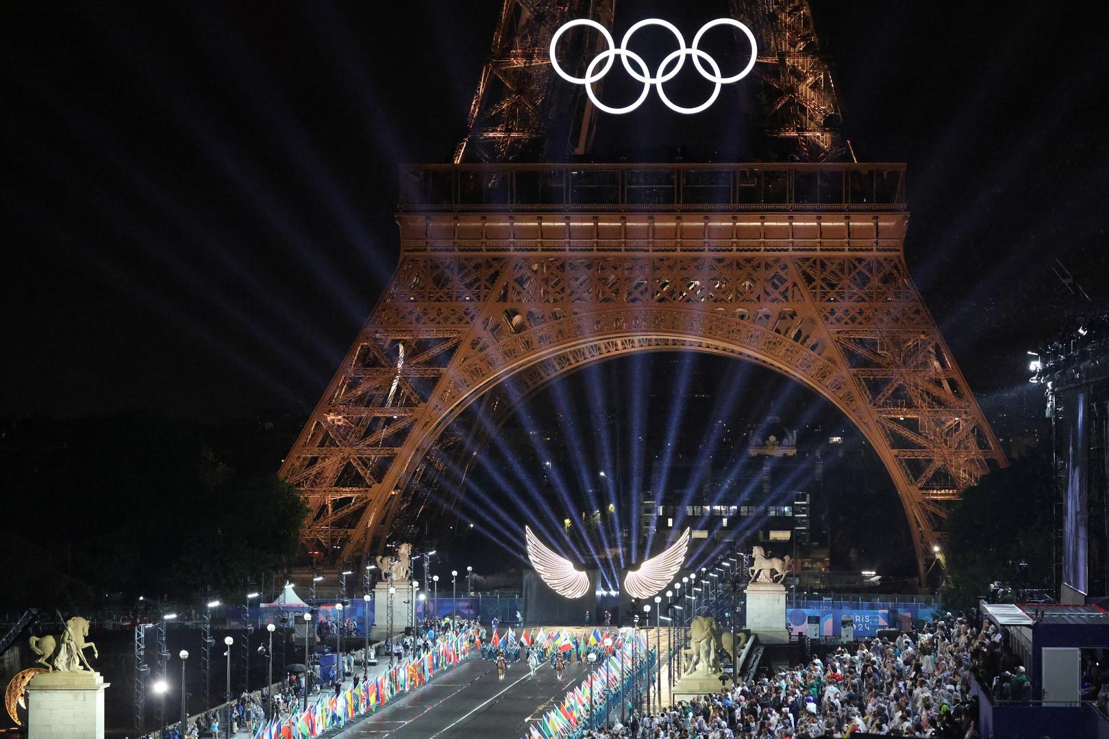 Paris 2024 Olympics - Opening Ceremony - Paris, France - July 26, 2024. Floriane Issert, a Gendarmerie non-commissioned officer of the National Gendarmerie, rides on a horse while leading volunteers carrying flags of Olympic teams on the Pont d'Iena during the opening ceremony of the Paris 2024 Olympic Games in Paris on July 26, 2024, as the Eiffel Tower is seen in the background.     LUDOVIC MARIN/Pool via REUTERS Photo: LUDOVIC MARIN/REUTERS