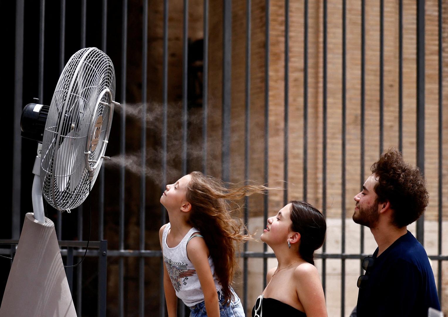 People stand in front of a cooler installed around the Colosseum amid a heatwave in Rome, Italy, June 21, 2024. REUTERS/Yara Nardi      TPX IMAGES OF THE DAY Photo: YARA NARDI/REUTERS