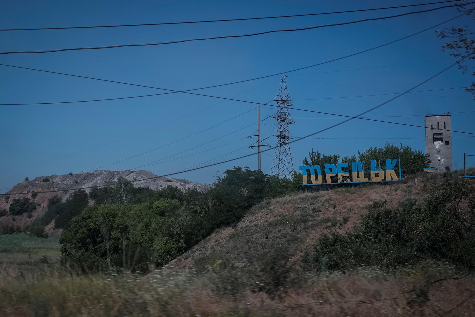 A view shows a damaged sign that reads "Toretsk", panted in the colours of the Ukrainian flag, near a coal mine building and a colliery spoil, in the town of Toretsk, amid Russia's attack on Ukraine, near a front line in Donetsk region, Ukraine July 3, 2024. REUTERS/Alina Smutko Photo: ALINA SMUTKO/REUTERS