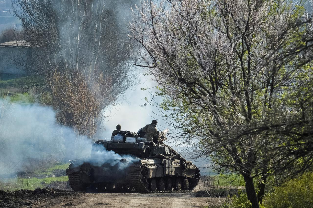 Ukrainian service members ride a tank near the front line city of Bakhmut