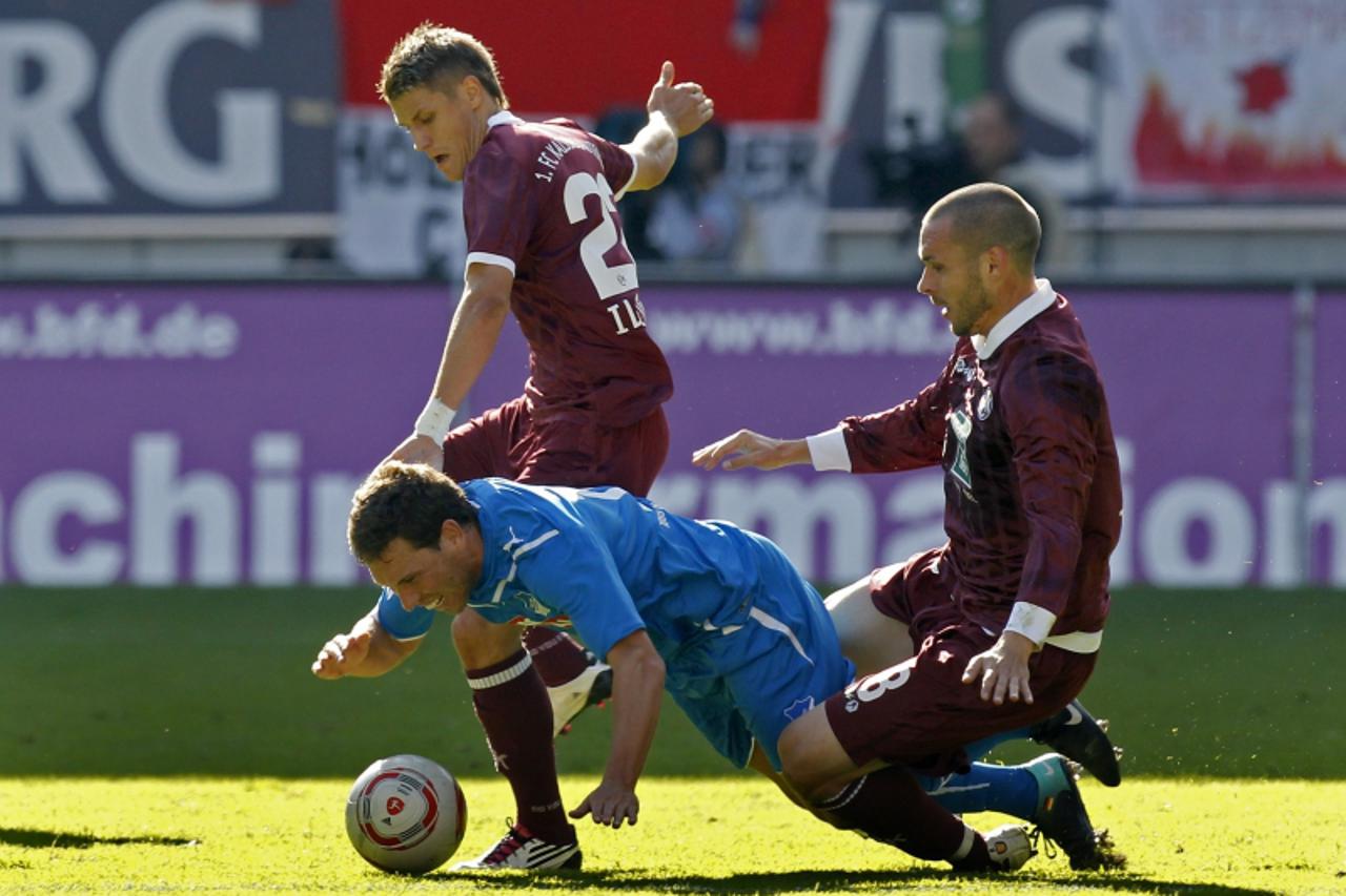 '1.FC Kaiserslautern\'s Ivo Ilicevic (L) and Christian Tiffert challenges TSG Hoffenheim\'s Tobias Weis during their German Bundesliga soccer match in Kaiserslautern September 18, 2010. REUTERS/Thomas