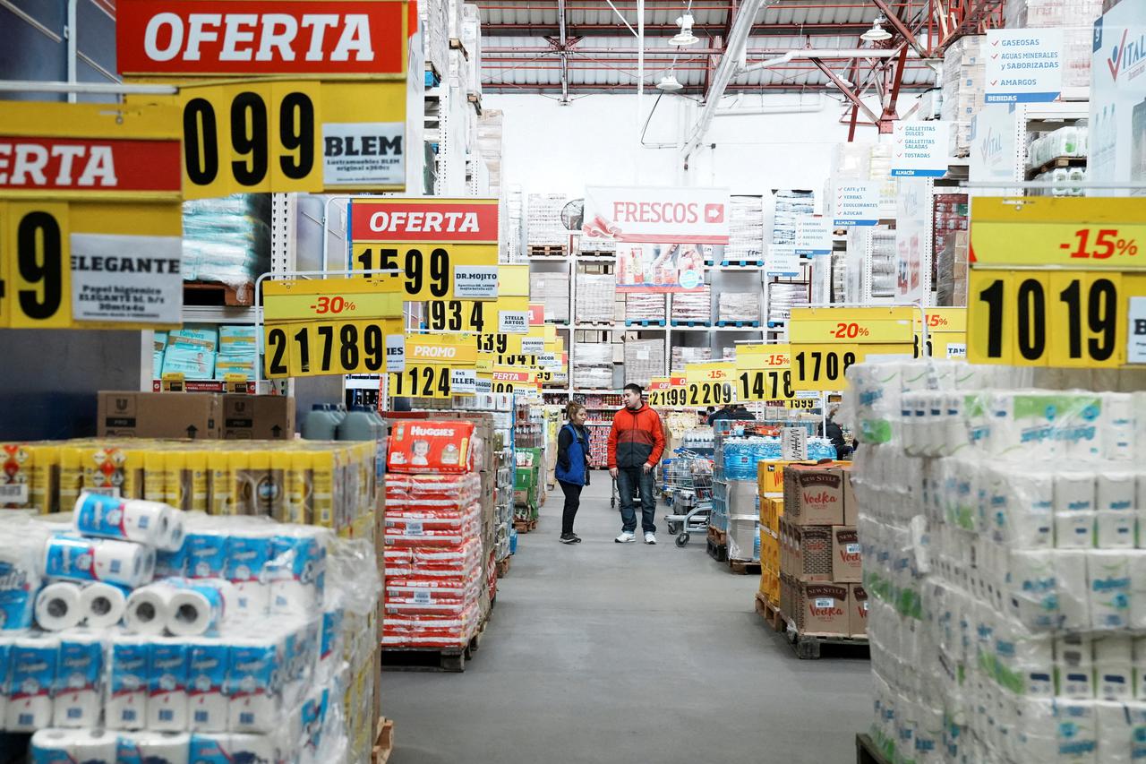 FILE PHOTO: Constumers check products at a wholesaler,as Argentina is due to release consumer inflation data for April, in Buenos Aires