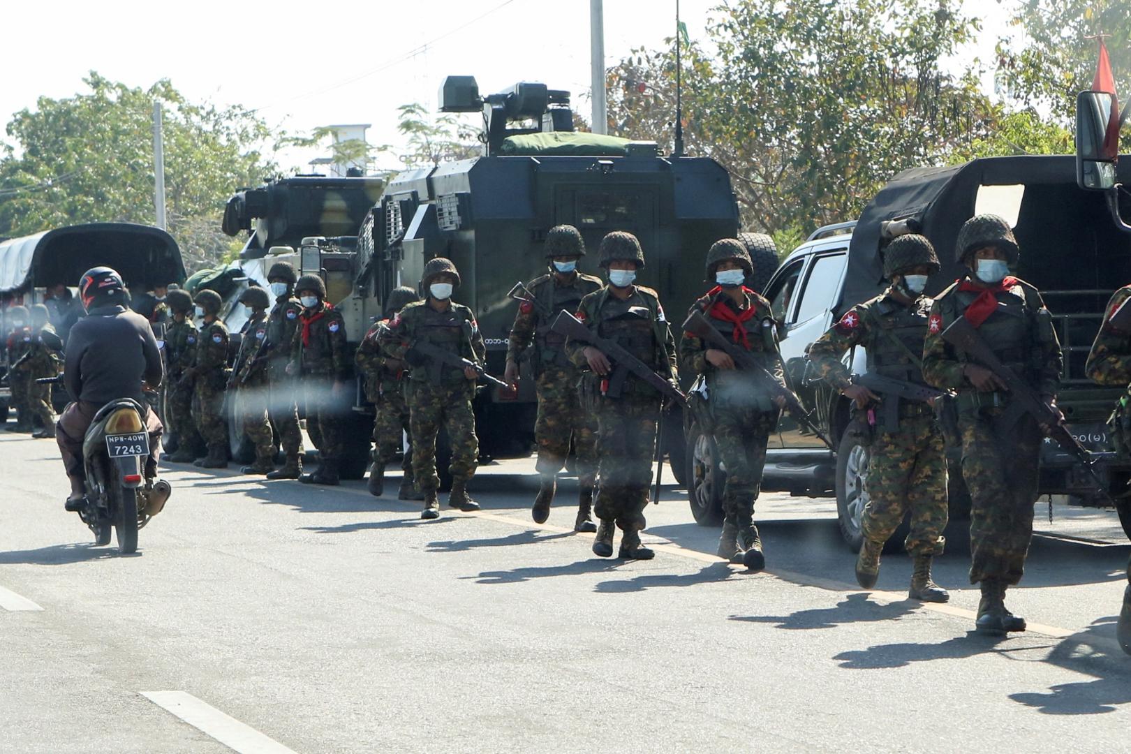 Soldiers walk as others stand guard next to armored vehicles in Naypyitaw Soldiers walk as others stand guard next to armored vehicles in Naypyitaw, Myanmar, February 15, 2021. REUTERS/Stringer NO RESALES. NO ARCHIVES STRINGER