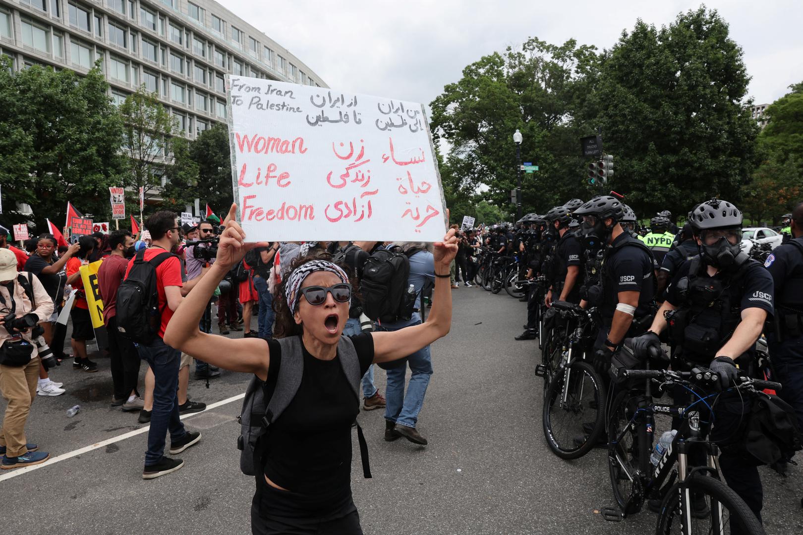 A pro-Palestinian demonstrator holds a sign near police officers, on the day Israeli Prime Minister Benjamin Netanyahu addresses a joint meeting of Congress, on Capitol Hill, in Washington, U.S., July 24, 2024. REUTERS/Umit Bektas Photo: UMIT BEKTAS/REUTERS