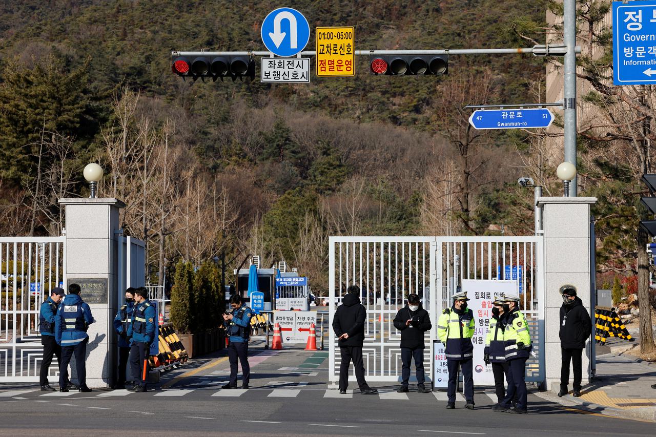 Police officers gather near the Corruption Investigation Office for High-ranking Officials as people await the arrival of impeached South Korean President Yoon Suk Yeol in Gwacheon