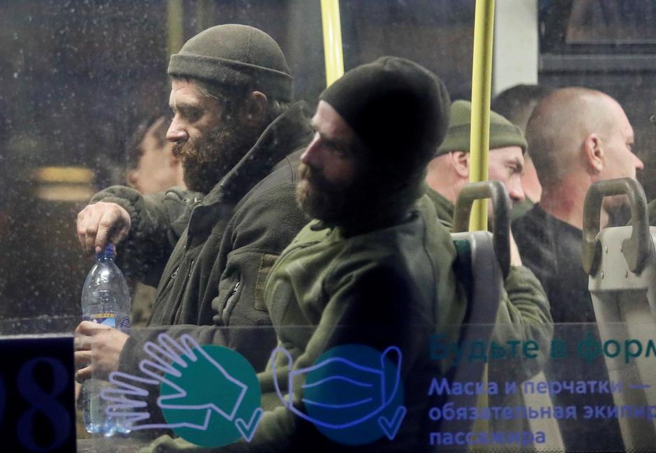 Buses carrying service members of Ukrainian forces who have surrendered after weeks holed up at Azovstal steel works arrive in Olenivka